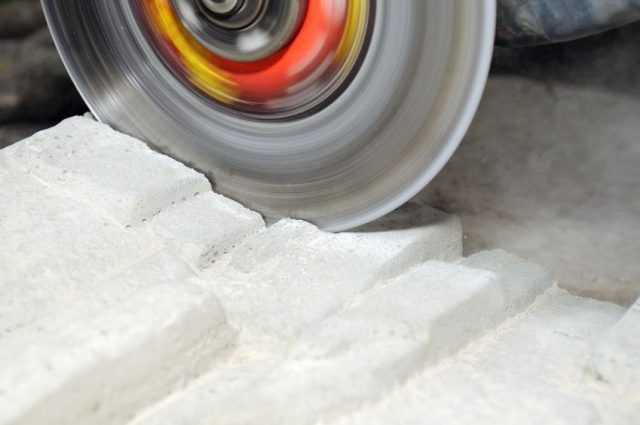 12336224 - grinder cutting concrete block